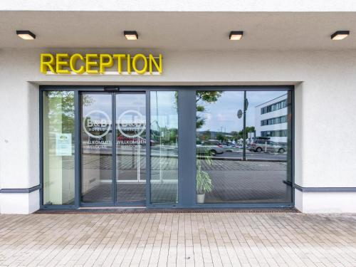 a store front with a sign that reads reception at B&B Hotel Landshut in Landshut