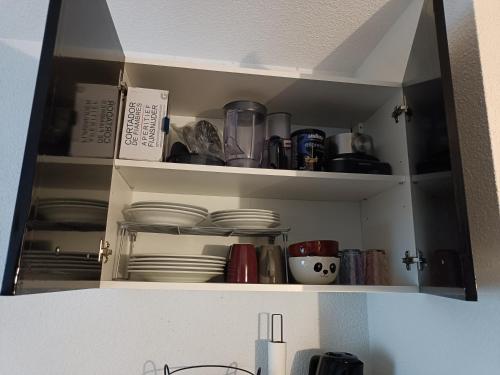 a kitchen cupboard with plates and dishes in it at Guzet Neige 1400 in Ustou