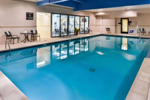 a large swimming pool with blue water in a building at Hilton Garden Inn Detroit Southfield in Southfield