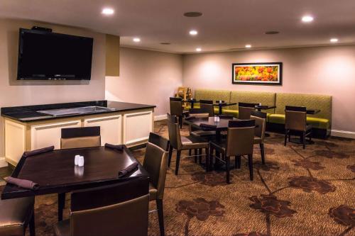 a restaurant with tables and chairs and a flat screen tv at Hilton Garden Inn Detroit Southfield in Southfield