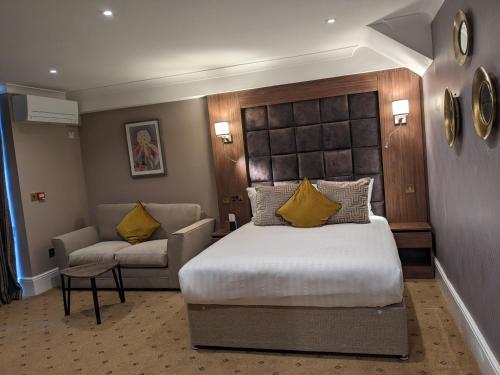 a hotel room with a bed and a couch at The Tudor Hotel in Harrow