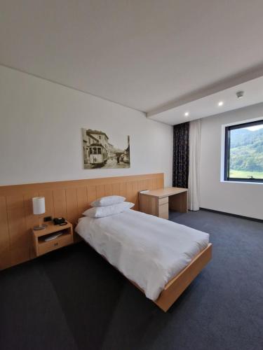 ein Hotelzimmer mit einem Bett und einem Fenster in der Unterkunft Hotel Coronado in Mendrisio