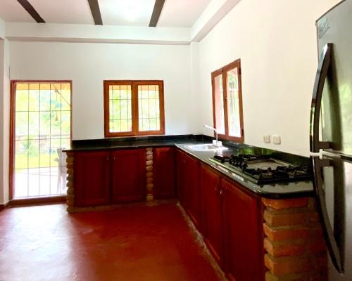 a kitchen with red cabinets and a stove at Minca Santa Marta Casa Scalea in Minca