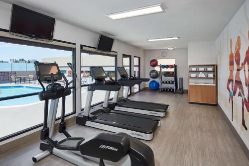a fitness room with cardio equipment and a swimming pool at Doubletree By Hilton Fullerton in Fullerton