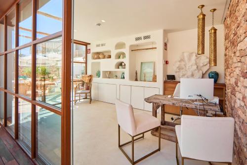 a kitchen and dining room with a table and chairs at Mar Suites Formentera by Universal Beach Hotels in Es Pujols