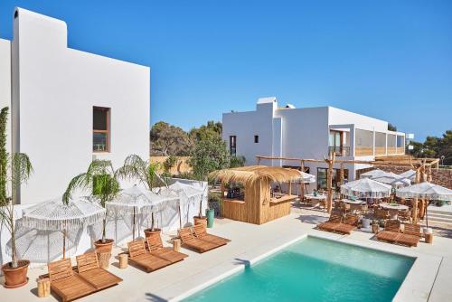 ein Resort mit einem Pool und Stühlen sowie einem Gebäude in der Unterkunft Mar Suites Formentera by Universal Beach Hotels in Es Pujols