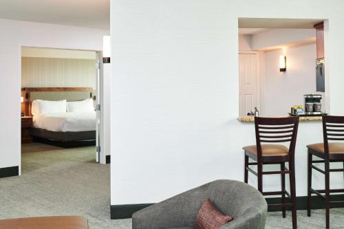 two pictures of a hotel room with a bed and a chair at Doubletree By Hilton Fullerton in Fullerton