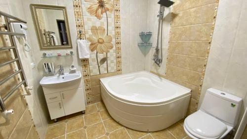 een badkamer met een bad, een toilet en een wastafel bij Alisher Hotel by SHOSH in Tasjkent