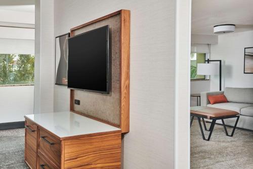 a living room with a flat screen tv on a wall at Doubletree By Hilton Fullerton in Fullerton