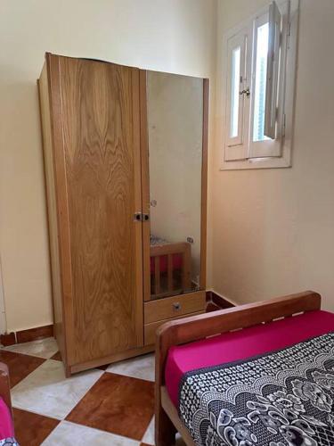 a bedroom with a large wooden cabinet and a bed at North coast rent Chalet / شاليه للايجار في الساحل in Dawwār Abū Duray‘ah ‘Abd al Karīm