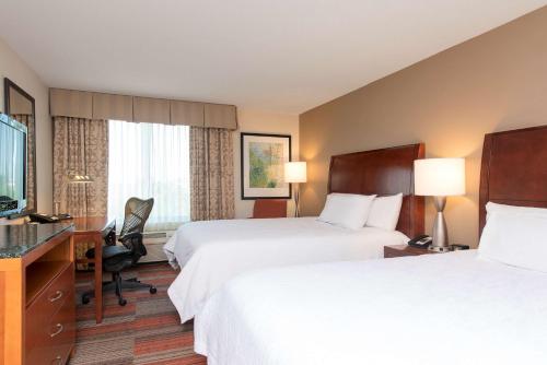 a hotel room with two beds and a flat screen tv at Hilton Garden Inn Lexington in Lexington