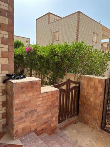 a brick fence with a gate in front of a house at North coast rent Chalet / شاليه للايجار في الساحل in Dawwār Abū Duray‘ah ‘Abd al Karīm