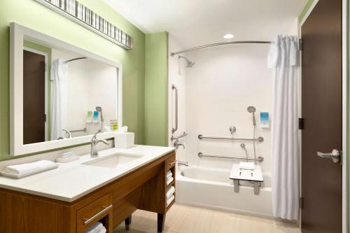 La salle de bains est pourvue d'un lavabo, d'une baignoire et d'une douche. dans l'établissement Home2 Suites By Hilton Hasbrouck Heights, à Hasbrouck Heights