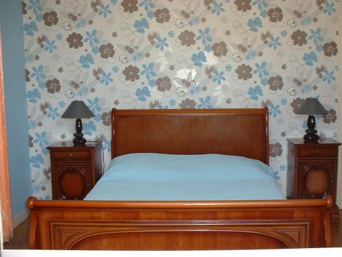 a bedroom with a wooden bed with two night stands at Chambres D'hôtes Bel'vue in Chauvigny