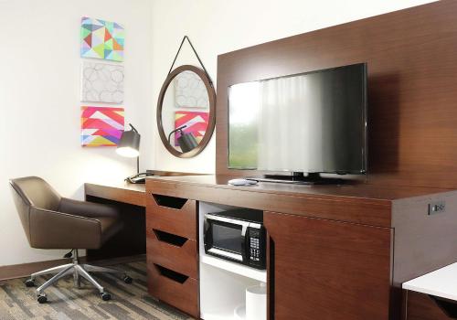 a room with a desk with a television and a chair at Hampton Inn and Suites Stephenville in Stephenville
