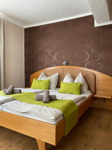 um quarto com uma cama de madeira e almofadas verdes em Gasthof Restaurant Steirereck'n em Schwanberg