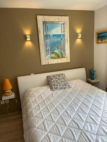 une chambre avec un lit et un tableau au mur dans l'établissement Le Californie, à Nice