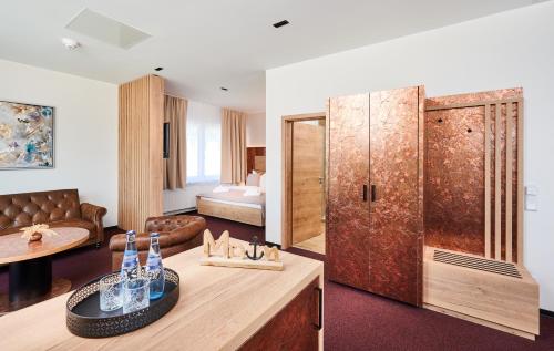 een woonkamer met een grote houten deur en een slaapkamer bij Hotel 53° Nord in Brake