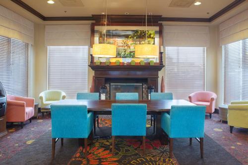 a dining room with a table and chairs and a fireplace at Hilton Garden Inn Bentonville Rogers in Bentonville