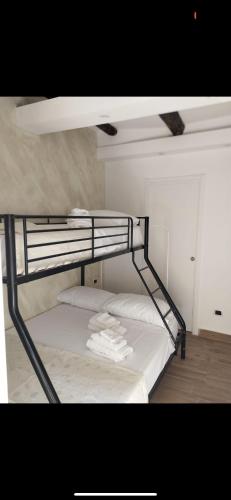 ein Etagenbett mit weißer Bettwäsche und Handtüchern darauf in der Unterkunft Casa Nina- Camera Capri in Neapel