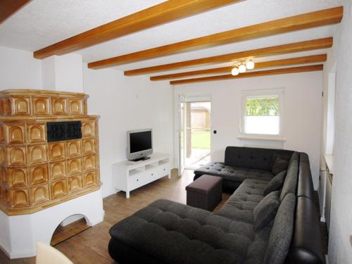 a living room with a couch and a tv at Birkenhof in Taching am See