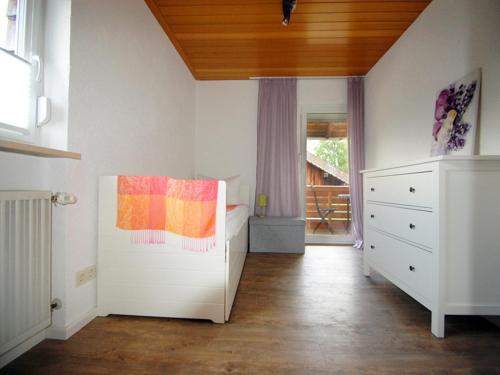 a bedroom with a bed and a dresser and a window at Birkenhof in Taching am See