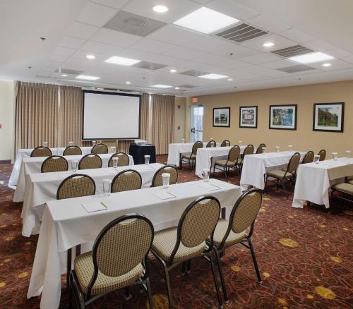 a conference room with tables and chairs and a screen at Hilton Garden Inn Bentonville Rogers in Bentonville