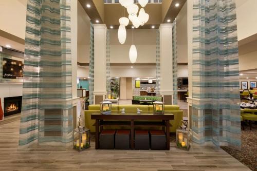 a lobby with a yellow couch and a table at Hilton Garden Inn Statesville in Statesville