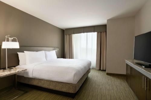a hotel room with a bed and a flat screen tv at Hilton Garden Inn Statesville in Statesville
