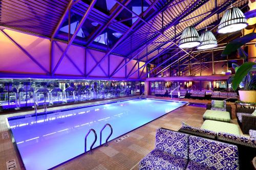 a large swimming pool with a bar in a building at Amway Grand Plaza Hotel, Curio Collection by Hilton in Grand Rapids