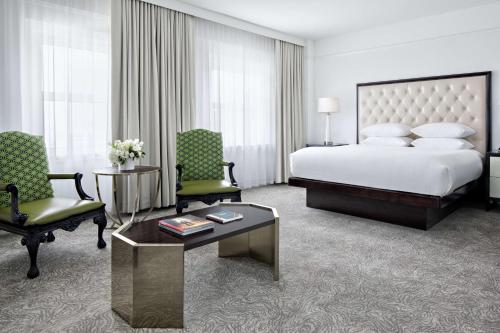 um quarto de hotel com uma cama e duas cadeiras e uma mesa em Amway Grand Plaza Hotel, Curio Collection by Hilton em Grand Rapids