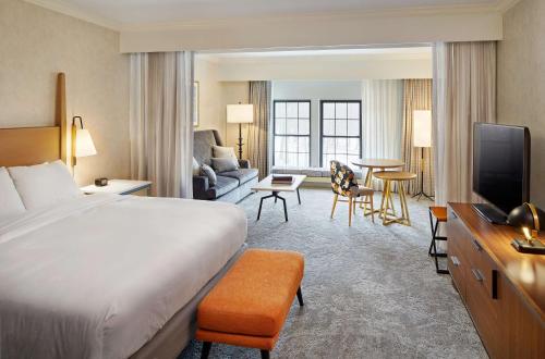 um quarto de hotel com uma cama e uma sala de estar em Hilton Pearl River em Pearl River