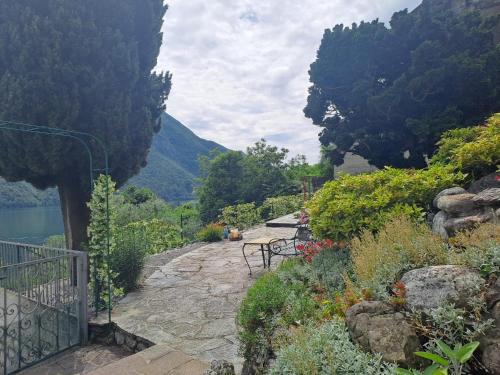 a stone walkway next to a lake with benches at Casamia Juliette in Valsolda