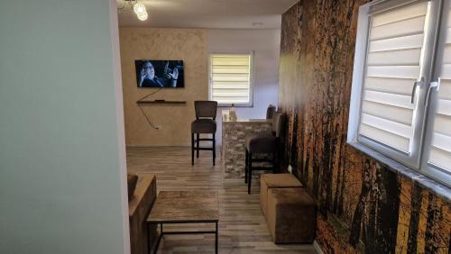 a living room with a table and chairs and a window at Apartmani Klačar in Gornje Pale