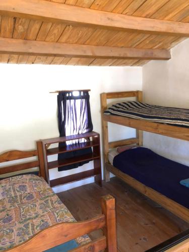Zimmer mit 2 Etagenbetten und einem Tisch in der Unterkunft REMODELAMOS casa sobre el rio a 100 mts del mercado municipal in Tilcara