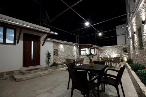 a patio with a table and chairs at night at Guesthouse Çani in Gjirokastër