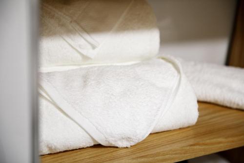 a stack of white towels sitting on a table at Guesthouse Çani in Gjirokastër