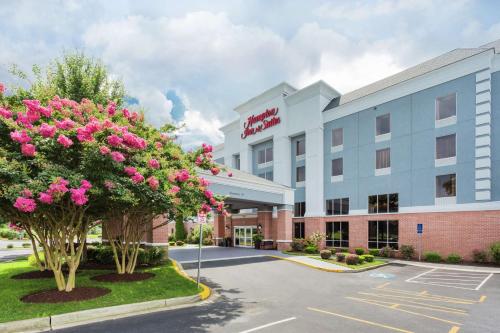 a hotel exterior with pink flowers in a parking lot at Hampton Inn & Suites Fruitland in Fruitland