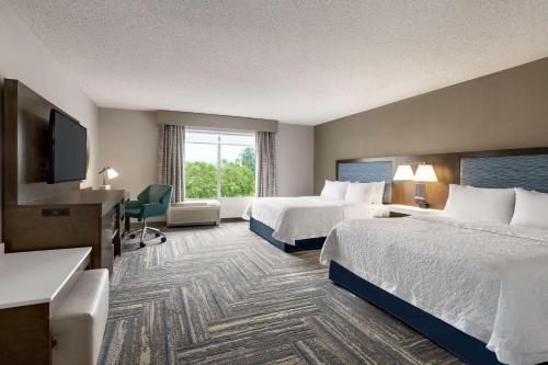 a hotel room with two beds and a flat screen tv at Hampton Inn & Suites Fruitland in Fruitland