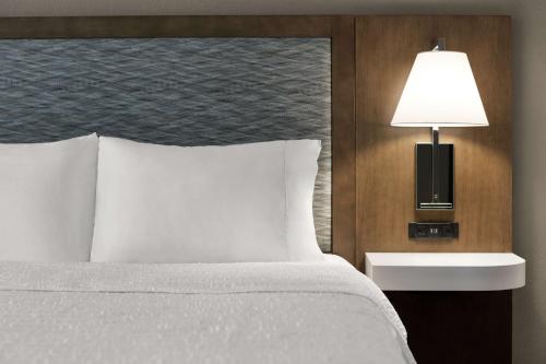 a bed in a hotel room with a lamp next to it at Hampton Inn & Suites Fruitland in Fruitland