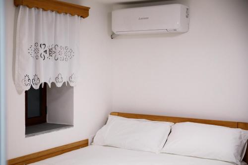 a bedroom with a bed and a air conditioner at Guesthouse Çani in Gjirokastër