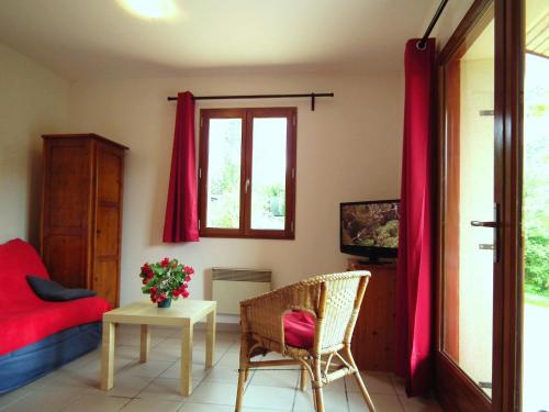 a bedroom with red curtains and a bed and a table at Detached house with dishwasher in south Dordogne in Gavaudun