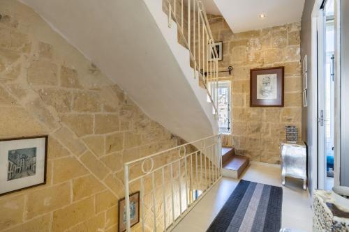 a staircase in a home with a stone wall at Valletta Bastions Seafront House in Valletta