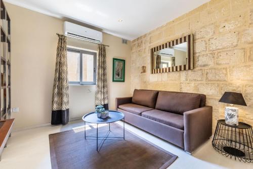 a living room with a couch and a table at Valletta Bastions Seafront House in Valletta