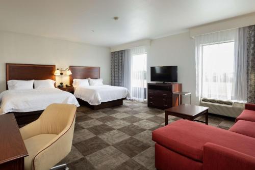 a hotel room with two beds and a couch at Hampton Inn & Suites Baton Rouge - I-10 East in Baton Rouge