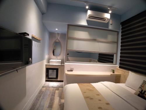 a bedroom with a bed and a large window and a television at 愛旅行民宿&近東大門夜市 in Hualien City
