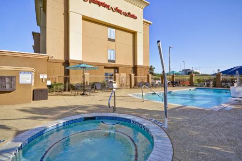 a hotel with a swimming pool in front of a building at Hampton Inn & Suites Brenham in Brenham