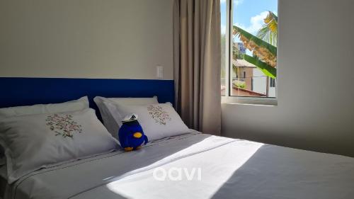 una cama con un objeto azul sentado encima de ella en Qavi - Flat em Pirangi Living #PirangiChalé13 en Parnamirim