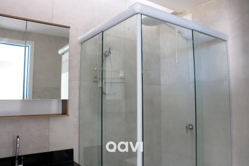 y baño con ducha de cristal y espejo. en Qavi - Flat em Pirangi Living #PirangiChalé13 en Parnamirim
