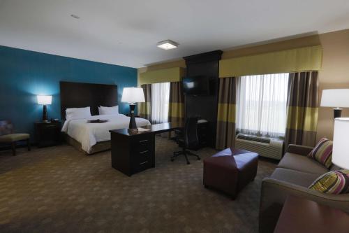 a hotel room with a bed and a desk and a couch at Hampton Inn and Suites Missouri City in Missouri City